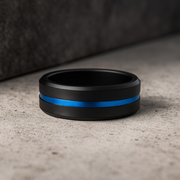 Black ring with a blue stripe on a textured surface