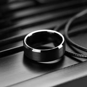 Black ring on a dark surface with a blurred background