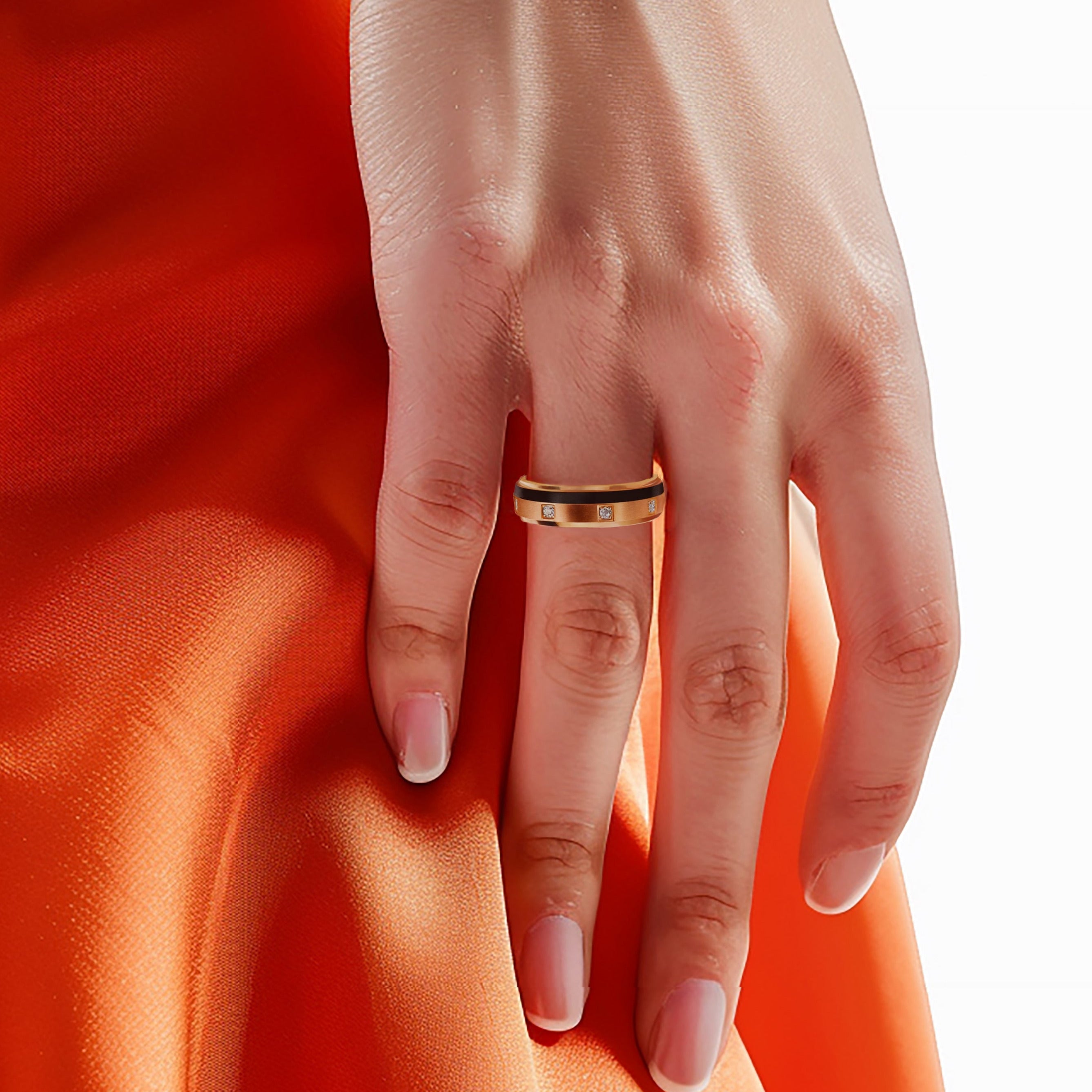 Hand wearing a ring on an orange fabric background
